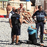 femeie musulmana aflata pe plaja obligata de politistii francezi sa dezbrace costumul burkini
